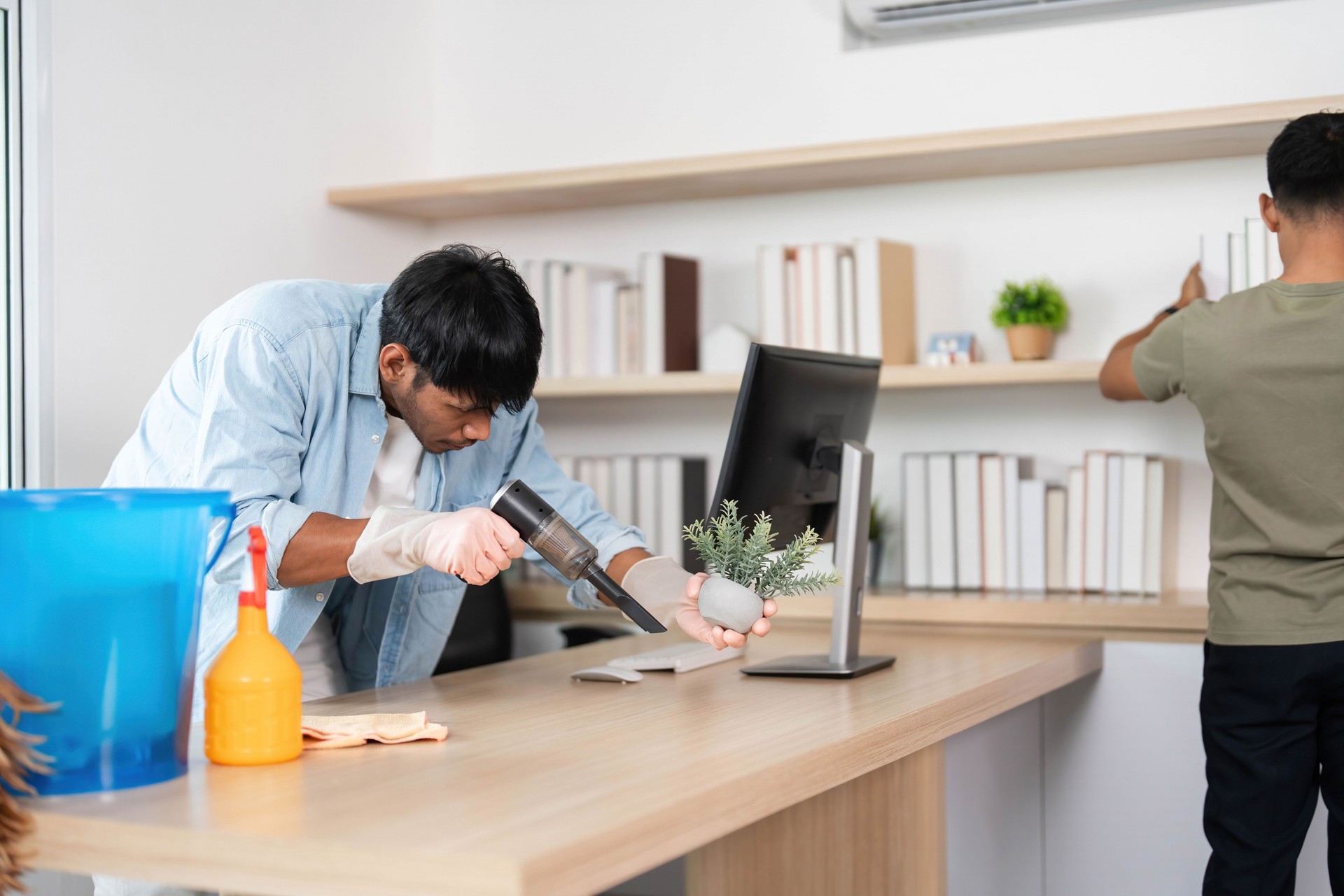 Office Cleaning Team. Two young men collaborating to maintain a clean workspace.